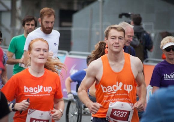 Two competitors running side by side in a race supporting Back Up